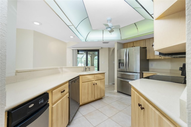 kitchen with ceiling fan, light brown cabinetry, a tray ceiling, light tile patterned floors, and appliances with stainless steel finishes