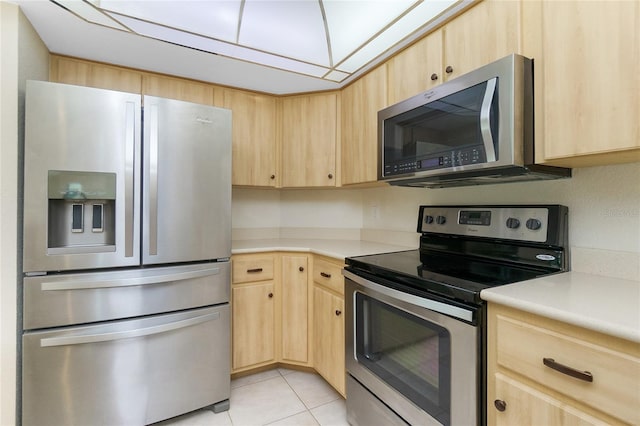 kitchen featuring light countertops, appliances with stainless steel finishes, and light brown cabinetry