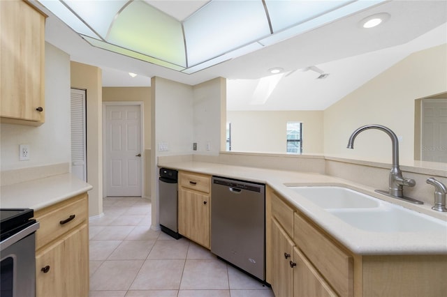 kitchen with light brown cabinetry, stainless steel appliances, light countertops, and a sink