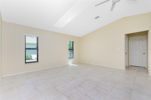 empty room with visible vents, a ceiling fan, light tile patterned floors, baseboards, and vaulted ceiling