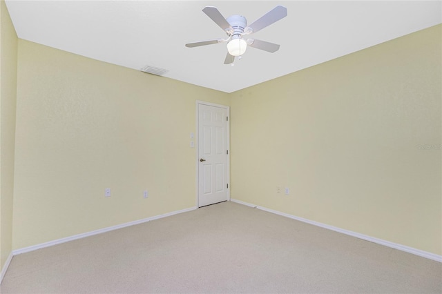 spare room with light carpet, visible vents, ceiling fan, and baseboards