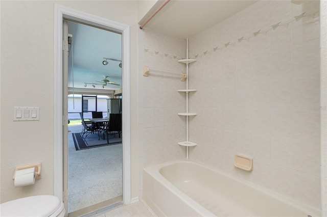 full bath featuring tile patterned flooring, bathing tub / shower combination, toilet, and a ceiling fan