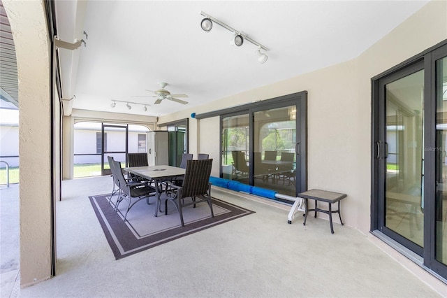 sunroom with rail lighting, plenty of natural light, and a ceiling fan