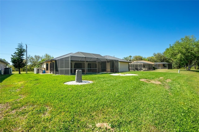 view of yard featuring glass enclosure and central AC