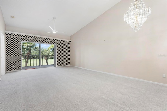 spare room featuring ceiling fan with notable chandelier, baseboards, carpet floors, and high vaulted ceiling