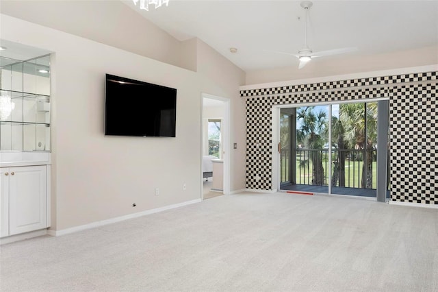 unfurnished living room with a wealth of natural light, light carpet, ceiling fan, and vaulted ceiling