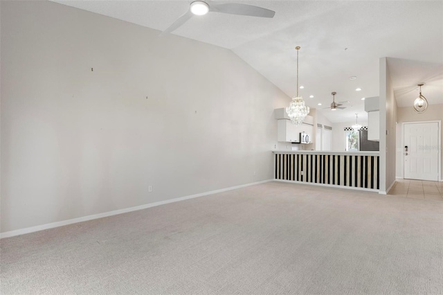 unfurnished living room with baseboards, lofted ceiling, recessed lighting, ceiling fan with notable chandelier, and light colored carpet