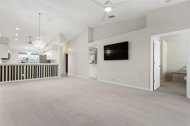 unfurnished living room with baseboards, lofted ceiling, recessed lighting, ceiling fan with notable chandelier, and light colored carpet