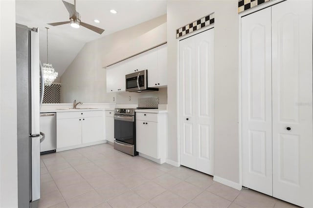 kitchen featuring ceiling fan with notable chandelier, a sink, stainless steel appliances, white cabinets, and light countertops