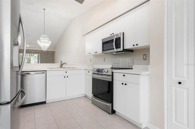 kitchen featuring a sink, appliances with stainless steel finishes, light countertops, a chandelier, and vaulted ceiling