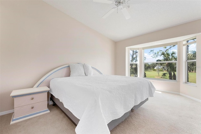 carpeted bedroom featuring baseboards, lofted ceiling, and a ceiling fan