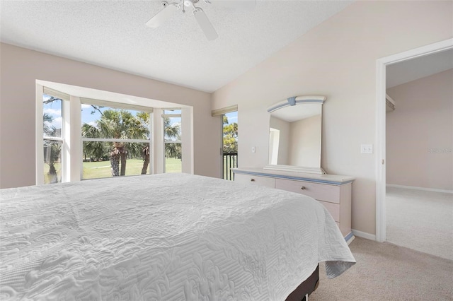 bedroom featuring baseboards, ceiling fan, vaulted ceiling, a textured ceiling, and light carpet