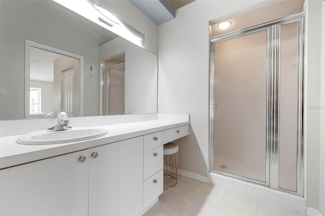 full bathroom featuring tile patterned flooring, a stall shower, vanity, and baseboards