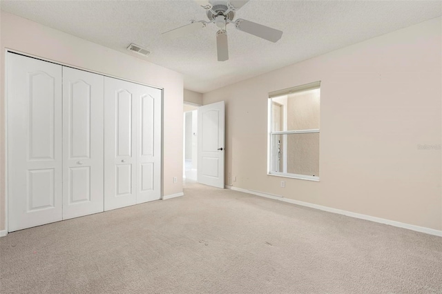 unfurnished bedroom featuring baseboards, visible vents, carpet floors, a closet, and a textured ceiling