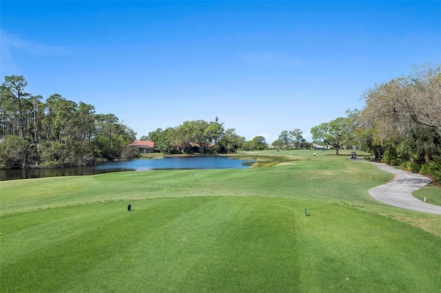 surrounding community with a water view and a lawn