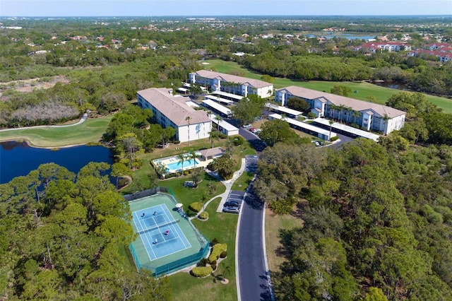 birds eye view of property with golf course view and a water view