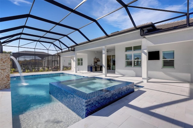 view of pool with glass enclosure, a pool with connected hot tub, ceiling fan, and a patio area