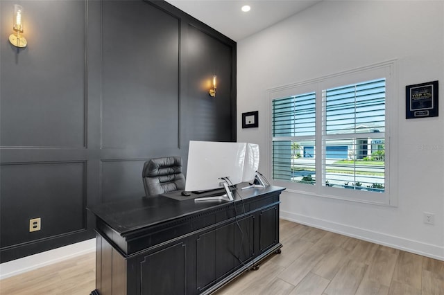 office space with recessed lighting, baseboards, light wood-style floors, and a decorative wall