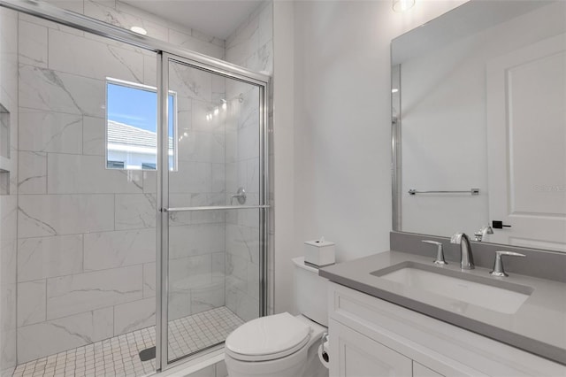 bathroom with a shower stall, toilet, and vanity