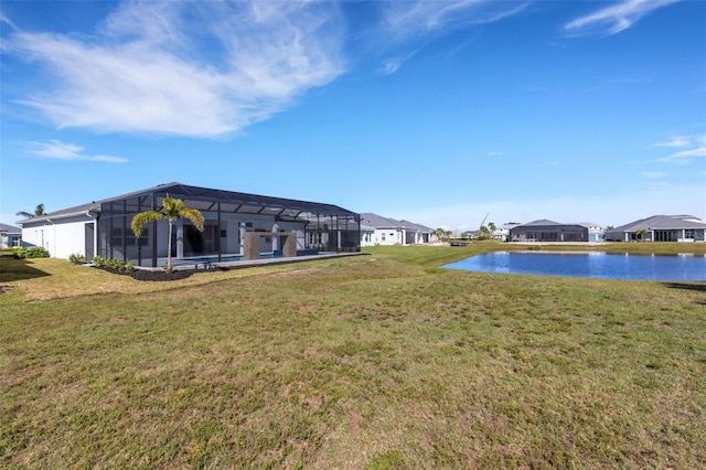 view of yard with a residential view, glass enclosure, and a water view