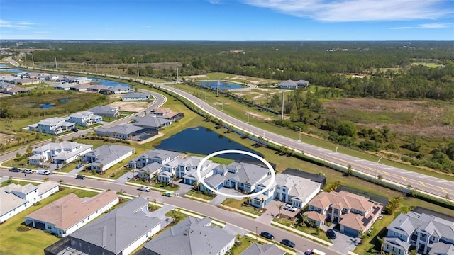 aerial view featuring a residential view, a wooded view, and a water view