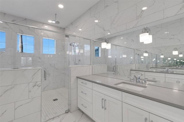 bathroom featuring tile walls, a shower stall, vanity, and marble finish floor