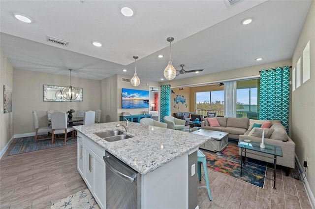 kitchen featuring a kitchen island with sink, a sink, white cabinets, dishwasher, and wood tiled floor