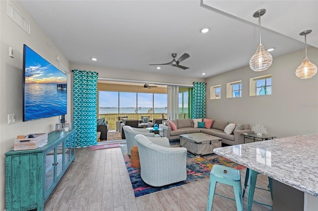 living area with recessed lighting, visible vents, wood finished floors, and a ceiling fan