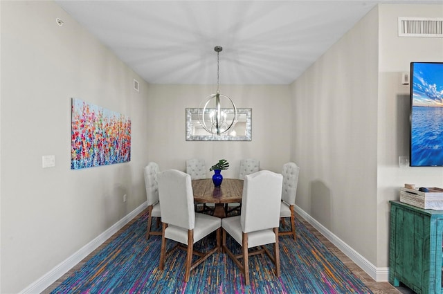 dining room featuring visible vents, baseboards, an inviting chandelier, and wood finished floors