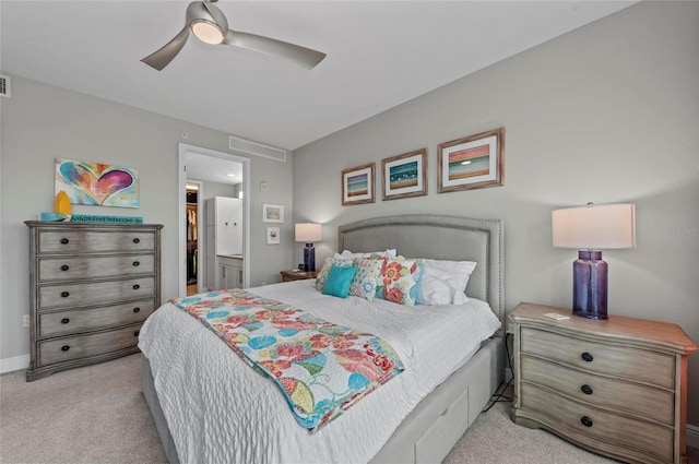 bedroom featuring visible vents, baseboards, ceiling fan, light carpet, and ensuite bathroom