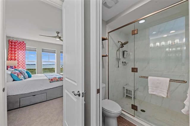 ensuite bathroom with connected bathroom, toilet, a shower stall, and a ceiling fan