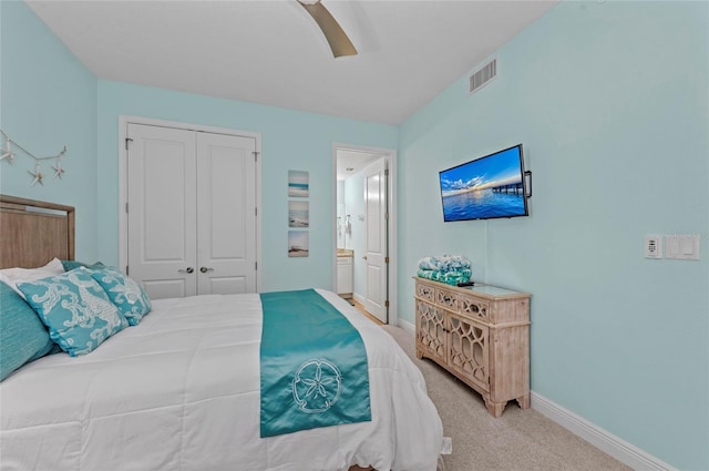 bedroom featuring visible vents, baseboards, a closet, and light carpet