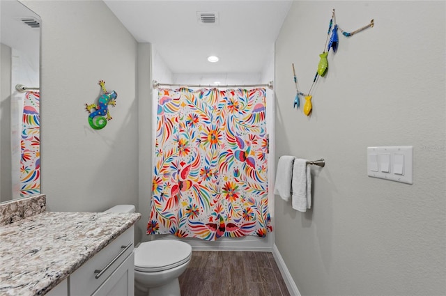 bathroom featuring vanity, wood finished floors, visible vents, baseboards, and toilet