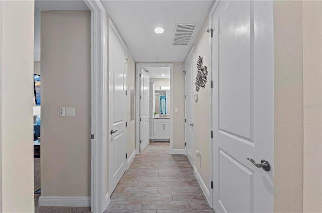 hall featuring visible vents, recessed lighting, light wood-style floors, and baseboards