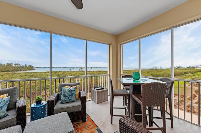 sunroom / solarium featuring a water view