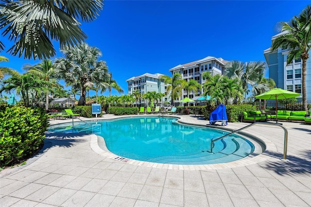 community pool with a patio area and fence