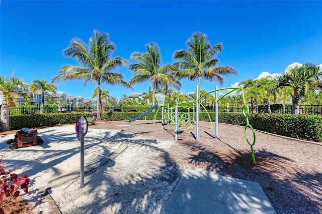 view of property's community with playground community and fence