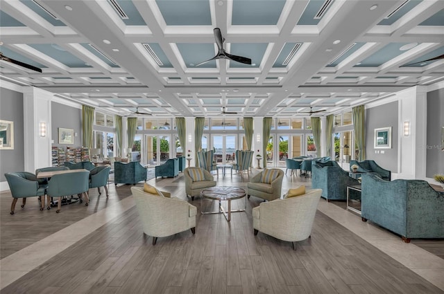 interior space with beamed ceiling, wood finished floors, coffered ceiling, and ceiling fan