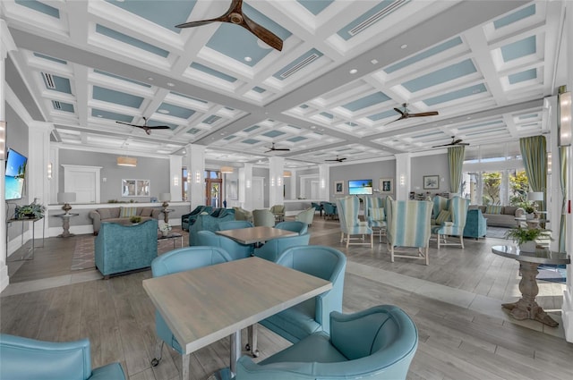 interior space with coffered ceiling, wood finished floors, and a ceiling fan