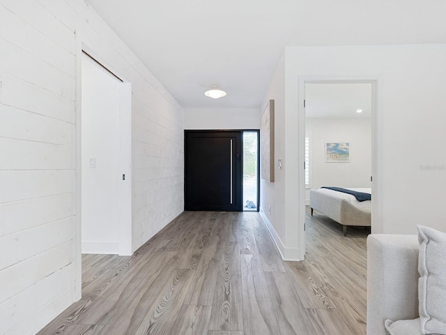 foyer with baseboards and light wood-style floors