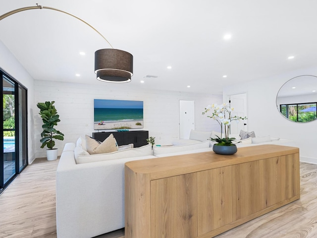 living room with recessed lighting, visible vents, baseboards, and light wood finished floors