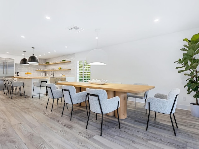 dining space featuring light wood finished floors, visible vents, recessed lighting, and baseboards