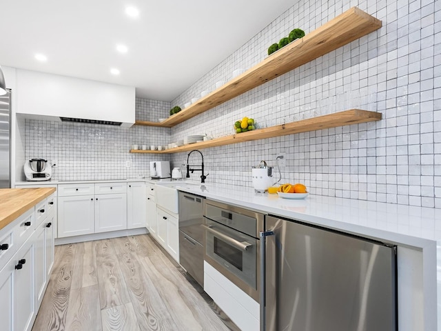 kitchen featuring fridge, light wood-style floors, and open shelves