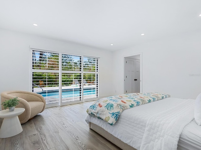 bedroom featuring access to exterior, recessed lighting, and wood finished floors