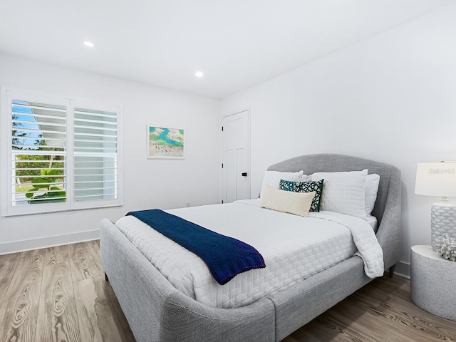 bedroom with recessed lighting, baseboards, and wood finished floors