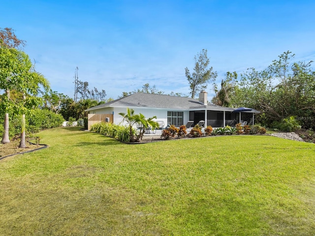 rear view of property with a lawn and a chimney