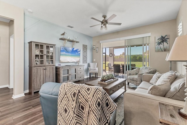 living room featuring baseboards, wood finished floors, visible vents, and ceiling fan