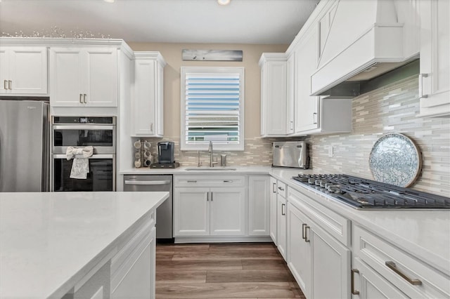 kitchen with a sink, stainless steel appliances, custom exhaust hood, and light countertops