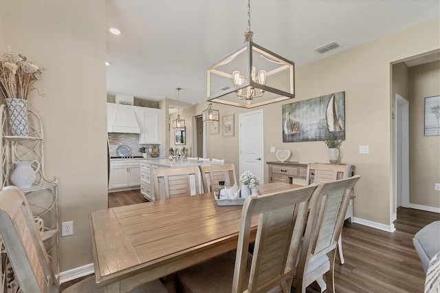 dining space with a notable chandelier, baseboards, visible vents, and dark wood-style flooring