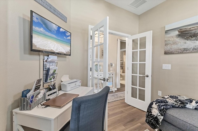 office space with visible vents, french doors, and wood finished floors